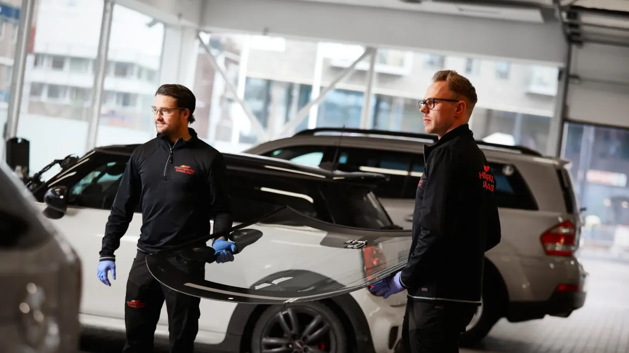 tekniker bærer en frontrute til en bil